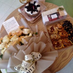 bento oreo cheesecake, french macaroons 3 kinds of frosted cinnamon bread and a flower bouquet